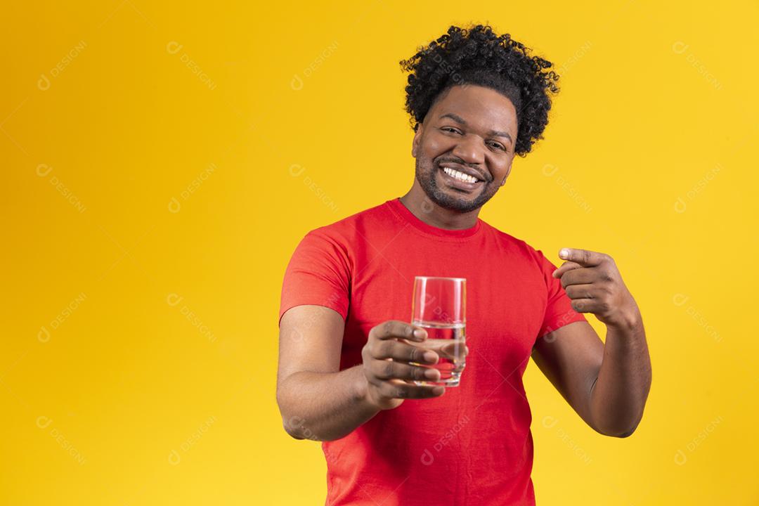 Homem afro bebendo copo de água sobre fundo isolado amarelo