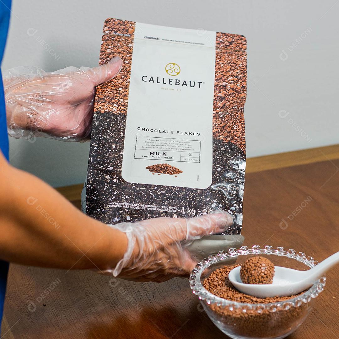 Pacote de granulados ao lado de colher com brigadeiro