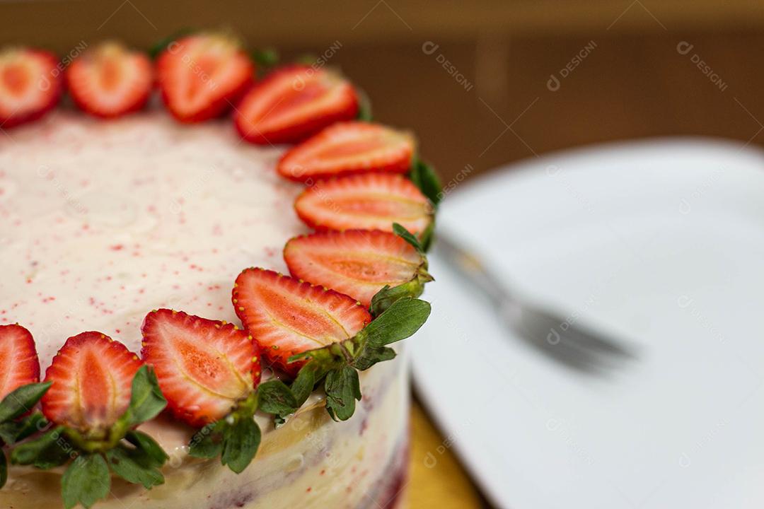 Bolo com recheio de morango com cobertura de chantilly, morangos por cima decorativo fundo desfocado