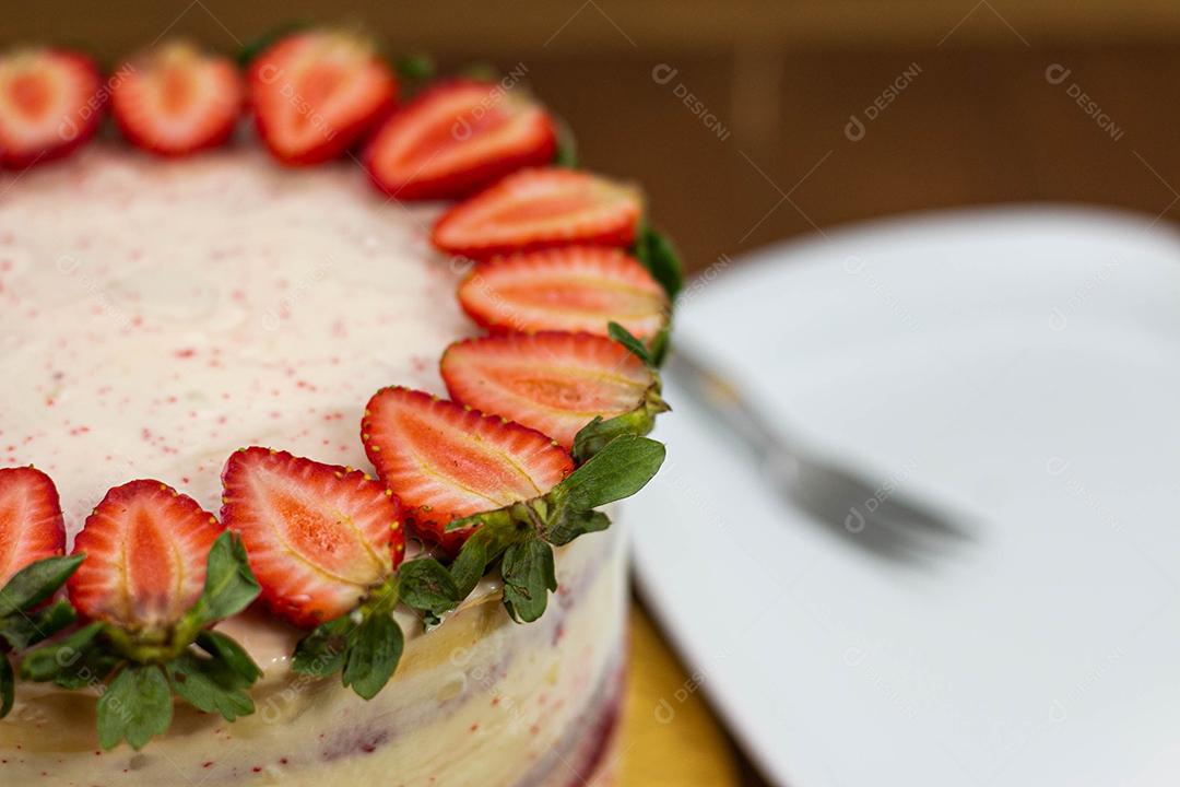 Bolo com recheio de morango com cobertura de chantilly, morangos por cima decorativo fundo desfocado