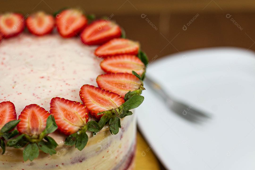 Bolo com recheio de morango com cobertura de chantilly, morangos por cima decorativo fundo desfocado