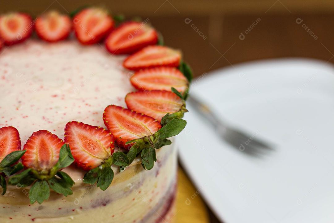 Bolo com recheio de morango com cobertura de chantilly, morangos por cima decorativo fundo desfocado