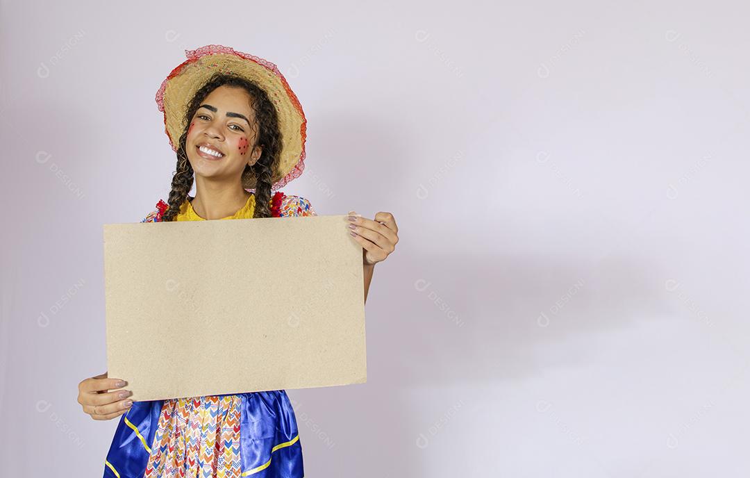 Linda mulher vestida com roupa de festa junina segurando quadro