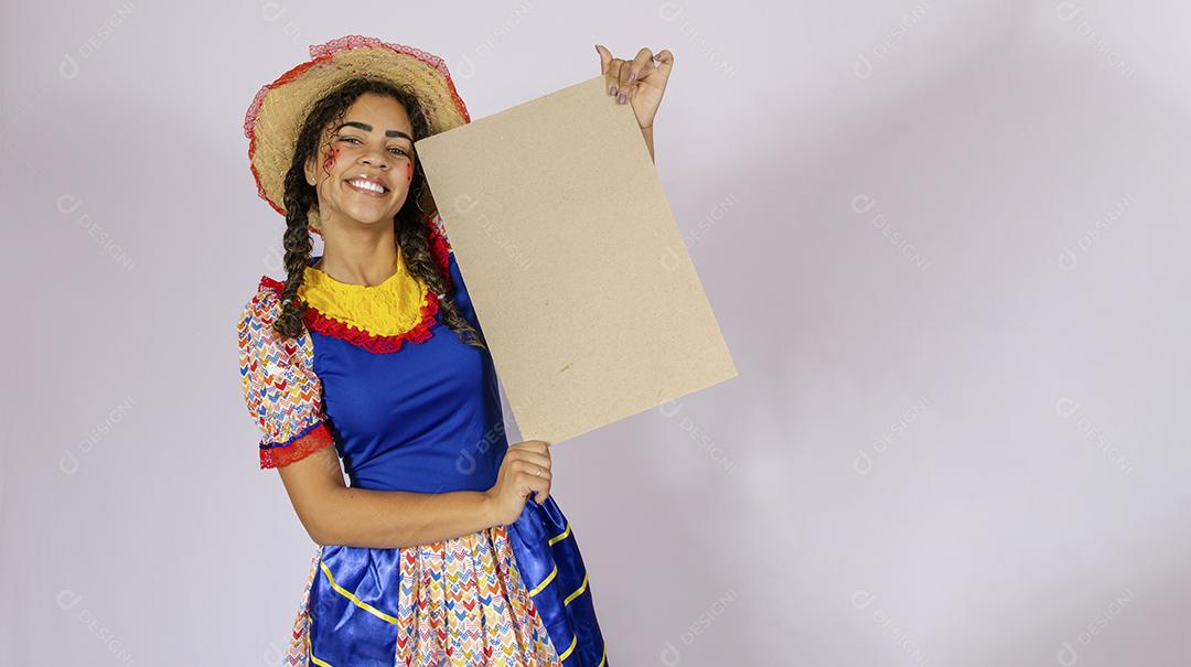 Linda mulher vestida com roupa de festa junina segurando quadro