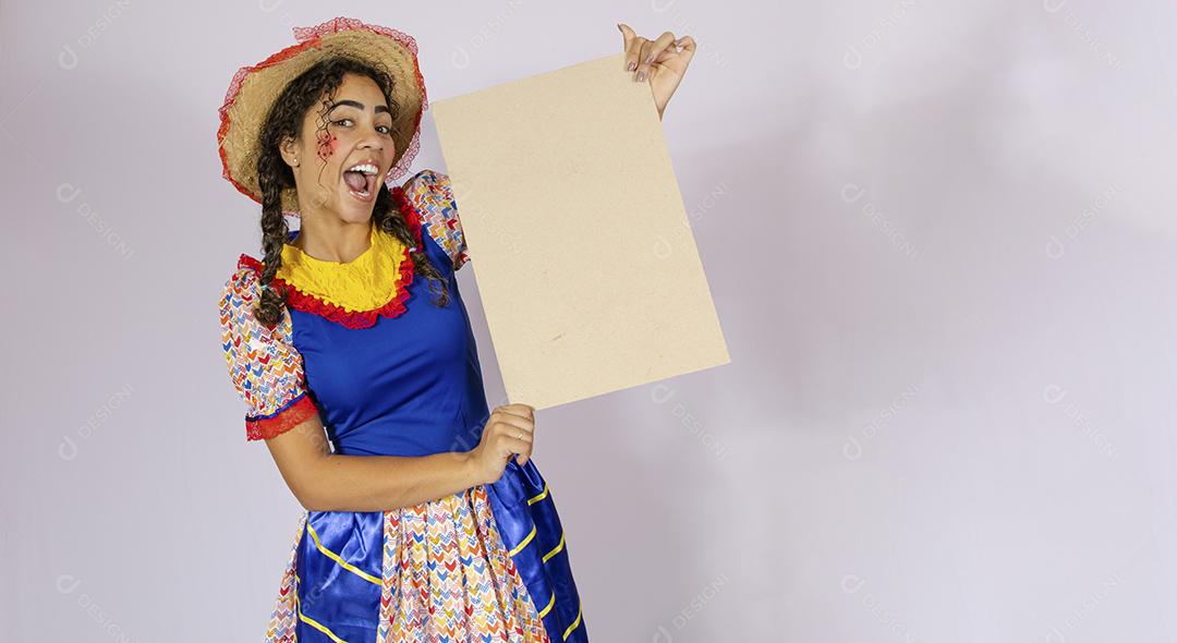 Linda mulher vestida com roupa de festa junina segurando quadro