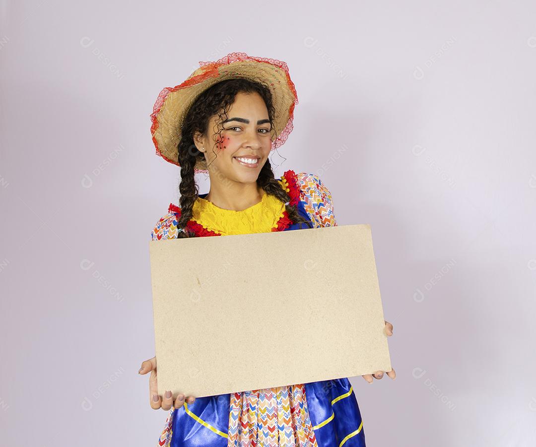 Linda mulher vestida com roupa de festa junina segurando quadro
