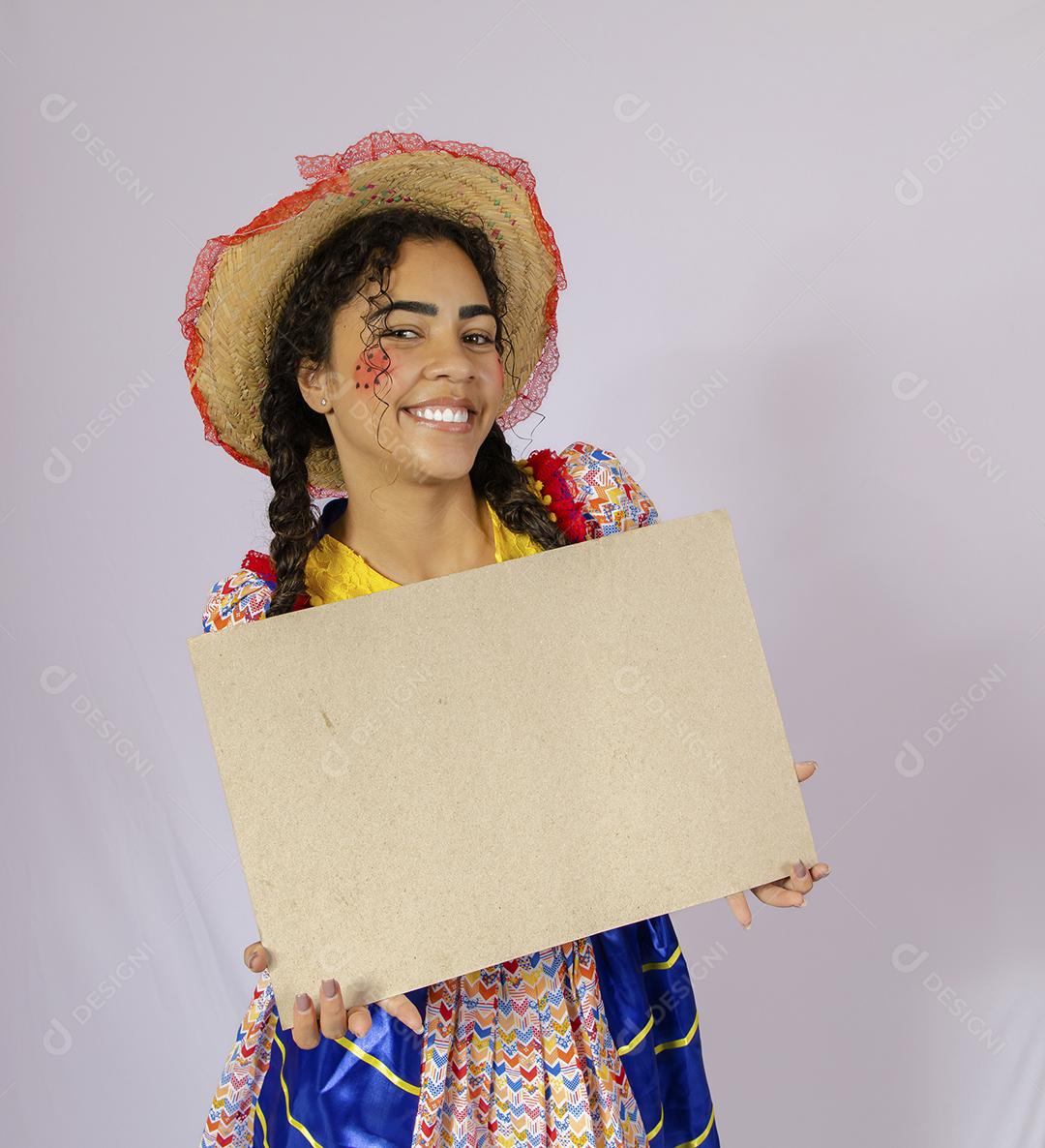Linda mulher vestida com roupa de festa junina segurando quadro