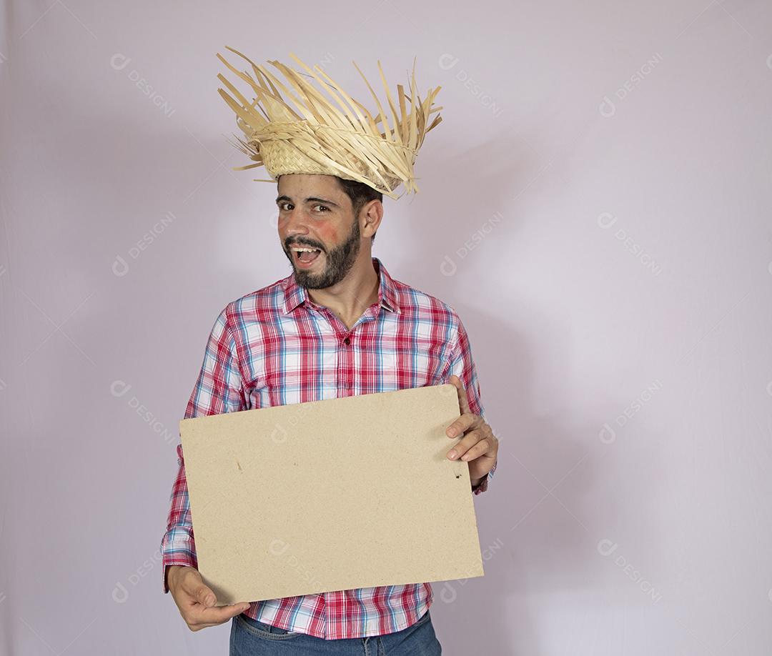 Homem brasileiro vestindo roupas típicas para Festa Junina e segurando quadro