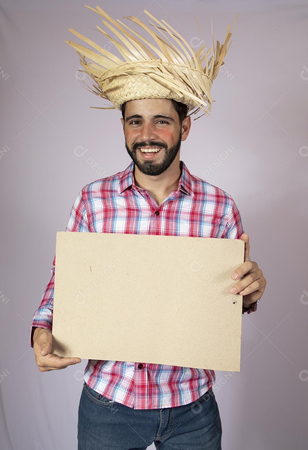 Homem brasileiro vestindo roupas típicas para Festa Junina e segurando quadro