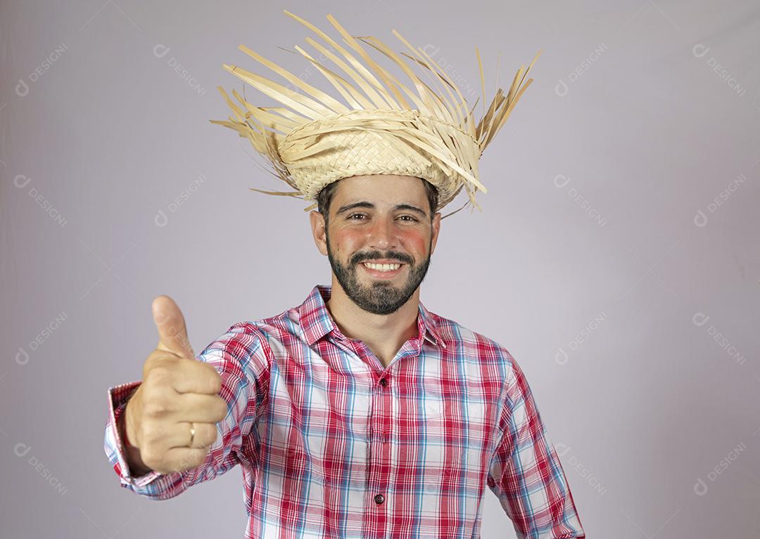 Homem brasileiro vestindo roupas típicas para Festa Junina fazendo sinal de ok