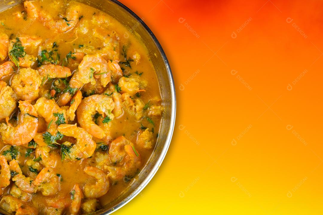 Deliciosa moqueca de camarão com fundo laranja vívido