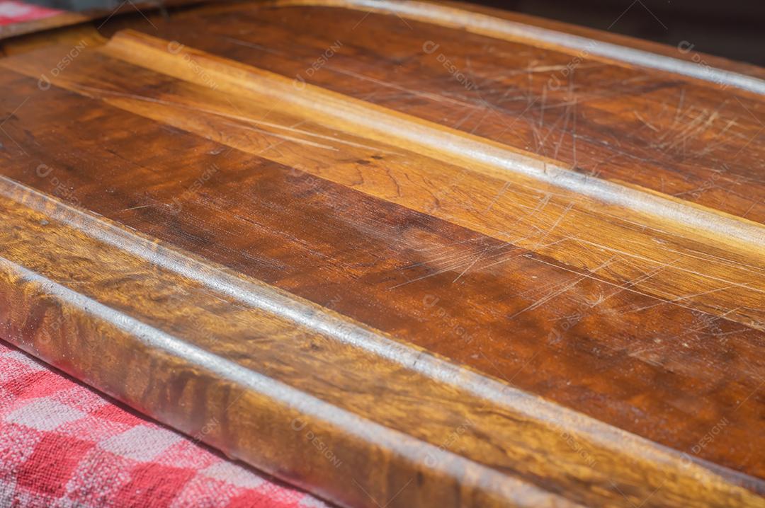 Tabuleta de madeira vazia com luz suave e pano vermelho por baixo.