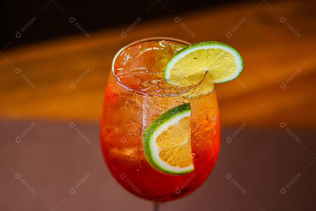 Taça com bebida laranja e limão em cima de mesa