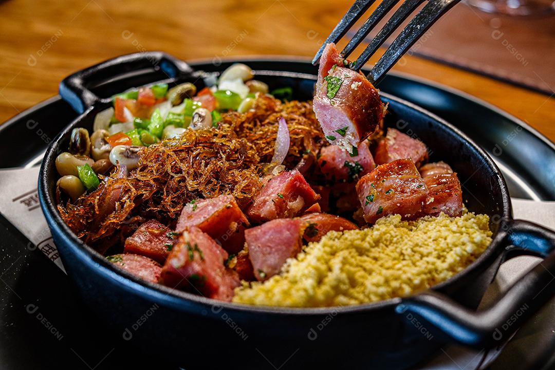 Panela de comida com cuscuz carne desfiada linguicinha e legumes