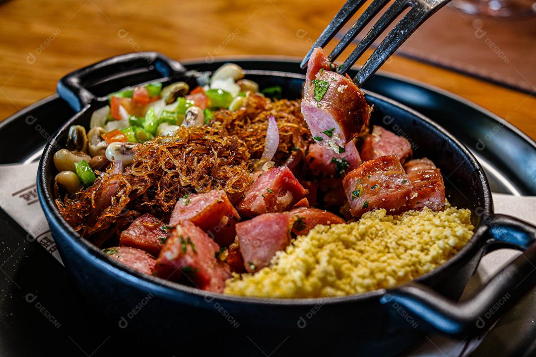 Panela preta com legumes linguicinhas e farofa