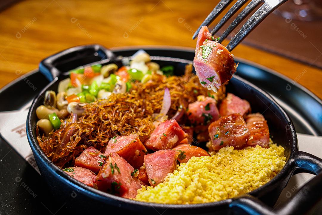 Panela de comida com cuscuz carne desfiada linguicinha e legumes