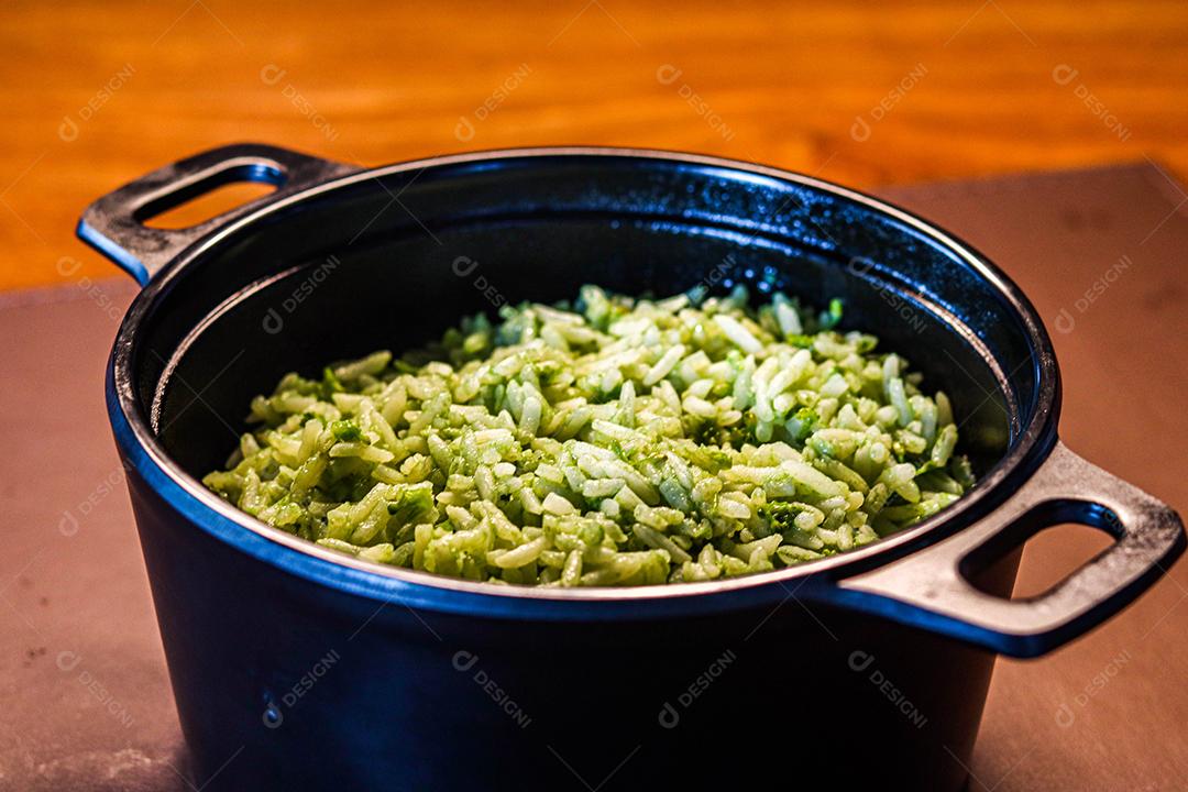 Panela de comida arroz verde acima de mesa