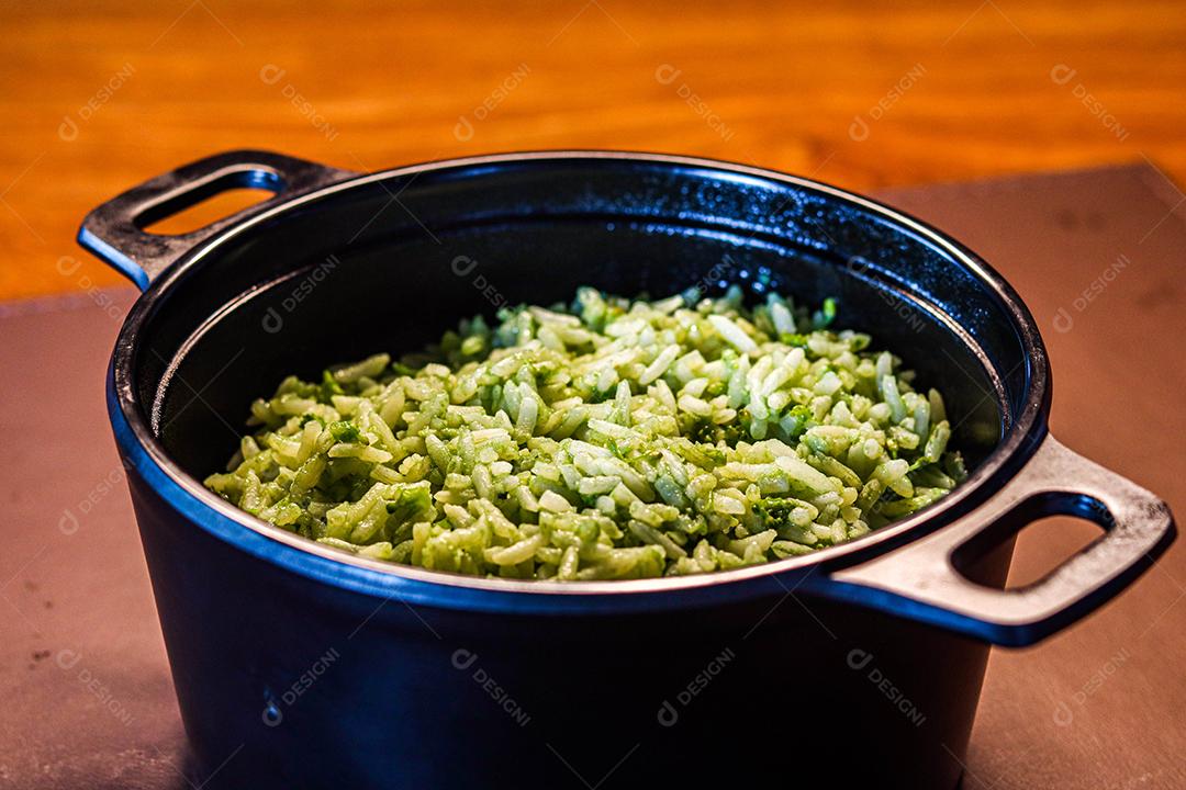 Panela de comida arroz verde acima de mesa