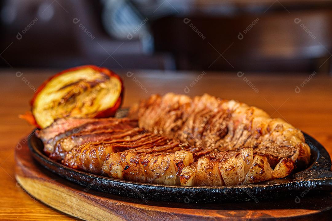 Tabua de madeira com carne mal passada e cebola