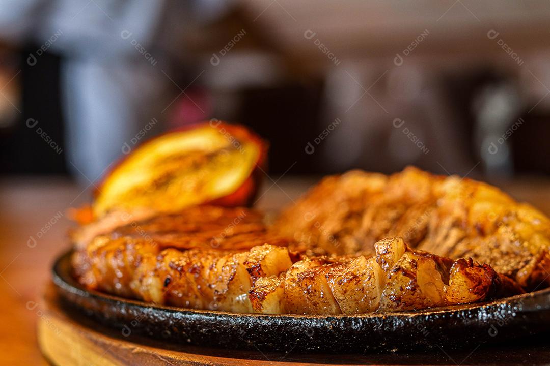 Tabua de madeira com carne mal passada e cebola