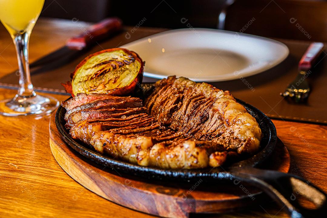 Tabua de madeira com carne mal passada e cebola