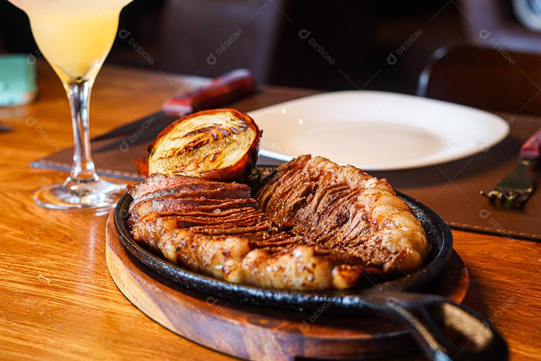 Tabua de madeira com carne mal passada e cebola