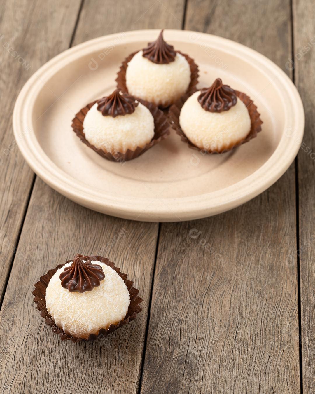 Brigadeiros gourmet típicos brasileiros, vários sabores sobre mesa de madeira.