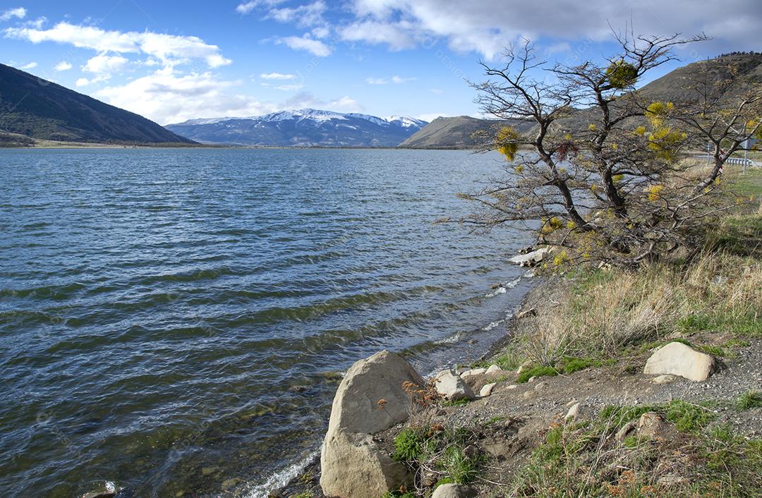 Lago perto de Puerto Natales Chile com montanhas de neve ao fundo