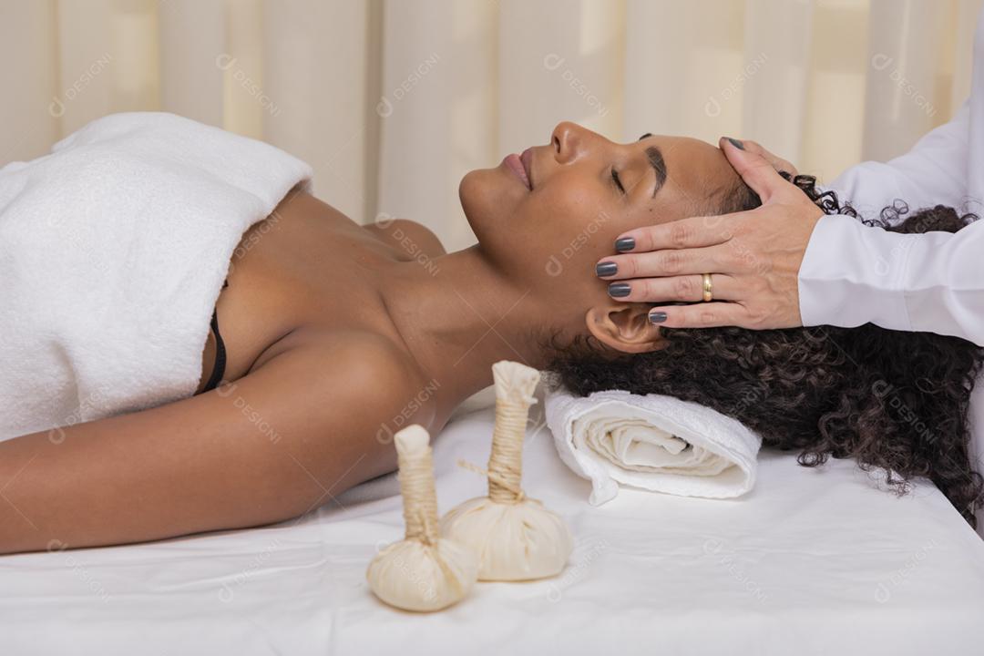 mulher recebendo massagem facial com pindas chinesas