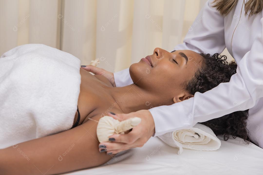 retrato de mulher atraente, desfrutando de massagem aromática com pind