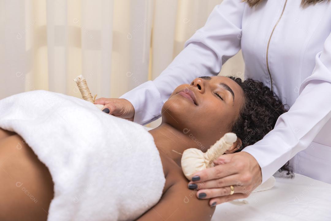 retrato de mulher atraente, desfrutando de massagem aromática com pind