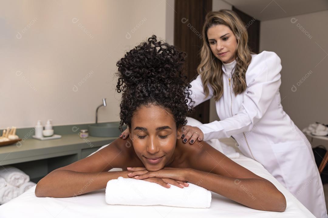 Mulher negra recebendo massagem no spa. Massagem