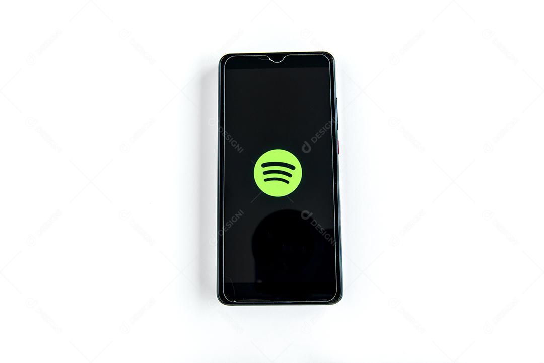 Aplicativo Spotify na tela do smartphone em fundo branco. Ijuí, Brasil