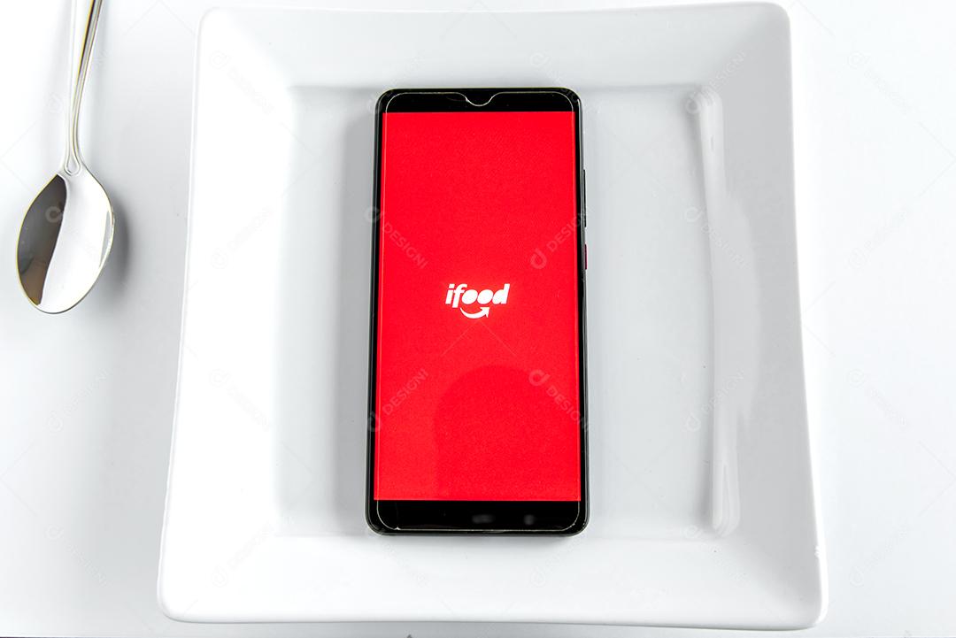 Aplicativo Ifood na tela do smartphone dentro do prato branco vazio. Ijuí Brasil