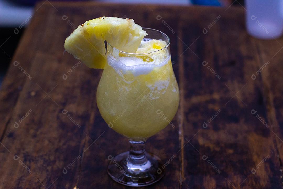 Cocktail de Abacaxi sobre mesa madeira.