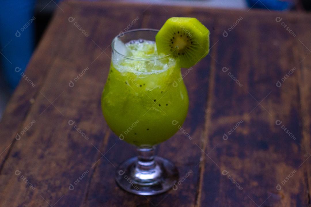 Cocktail de Kiwi sobre mesa madeira.