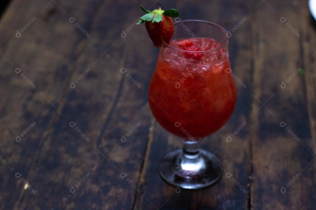 Cocktail de Morango sobre mesa madeira.