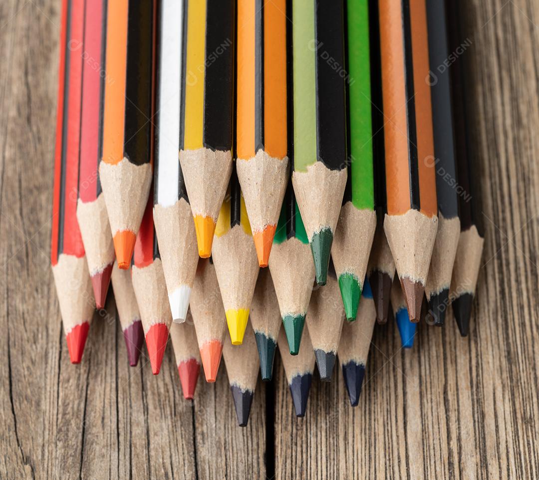 Lápis de cores sortidas sobre a mesa de madeira