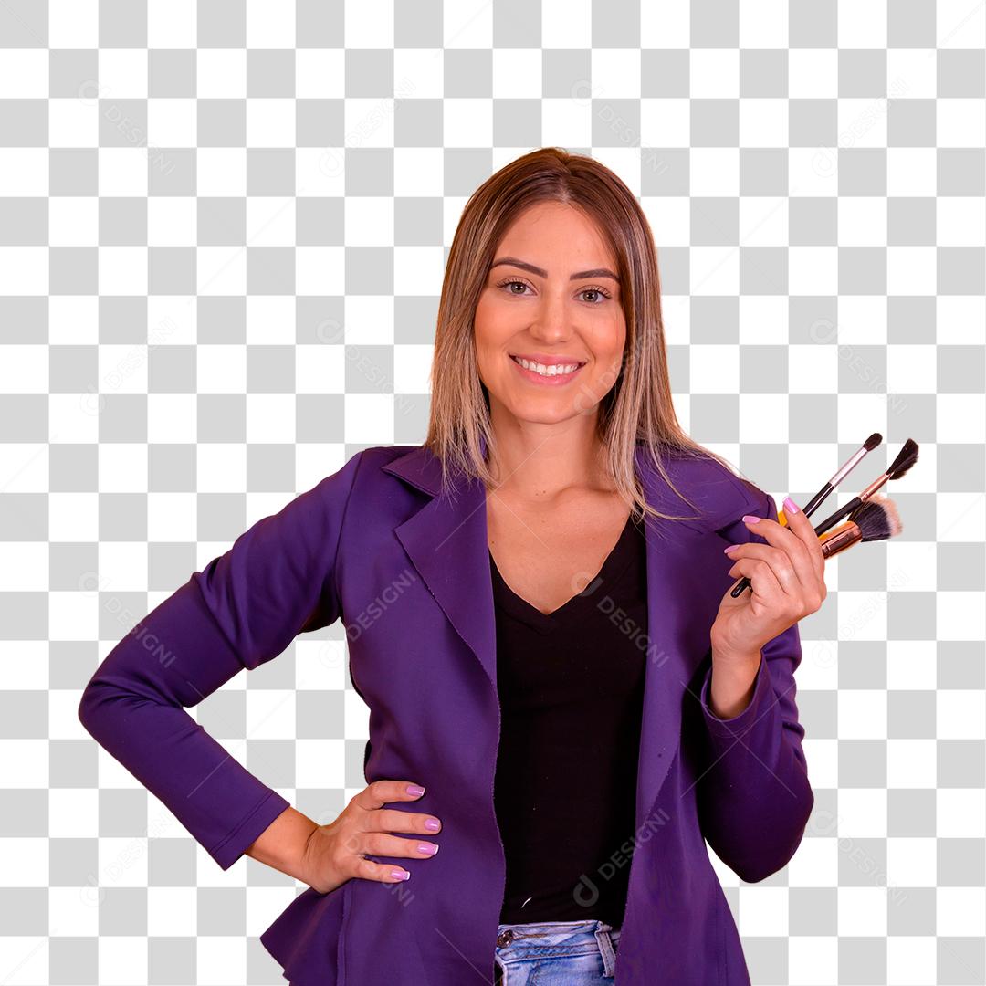 Mulher loira com um blazer roxo segurando pinceis de maquiagem