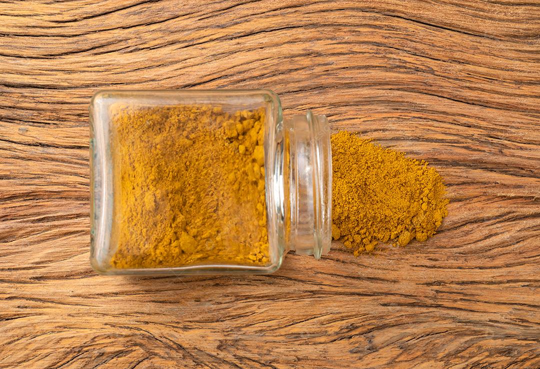 Açafrão em um pote de vidro sobre a mesa de madeira.