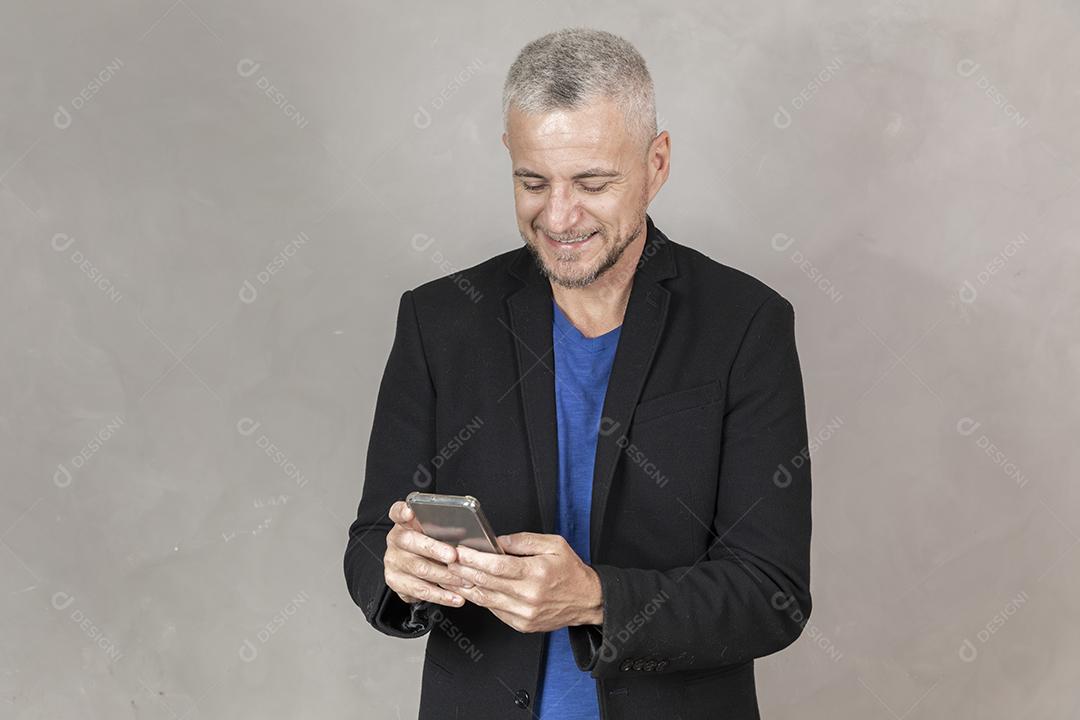 Homem grisalho de meia idade usando um smartphone