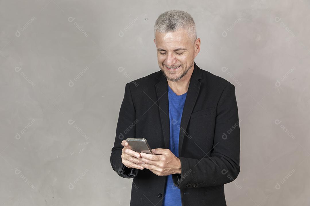 Homem grisalho de meia idade usando um smartphone