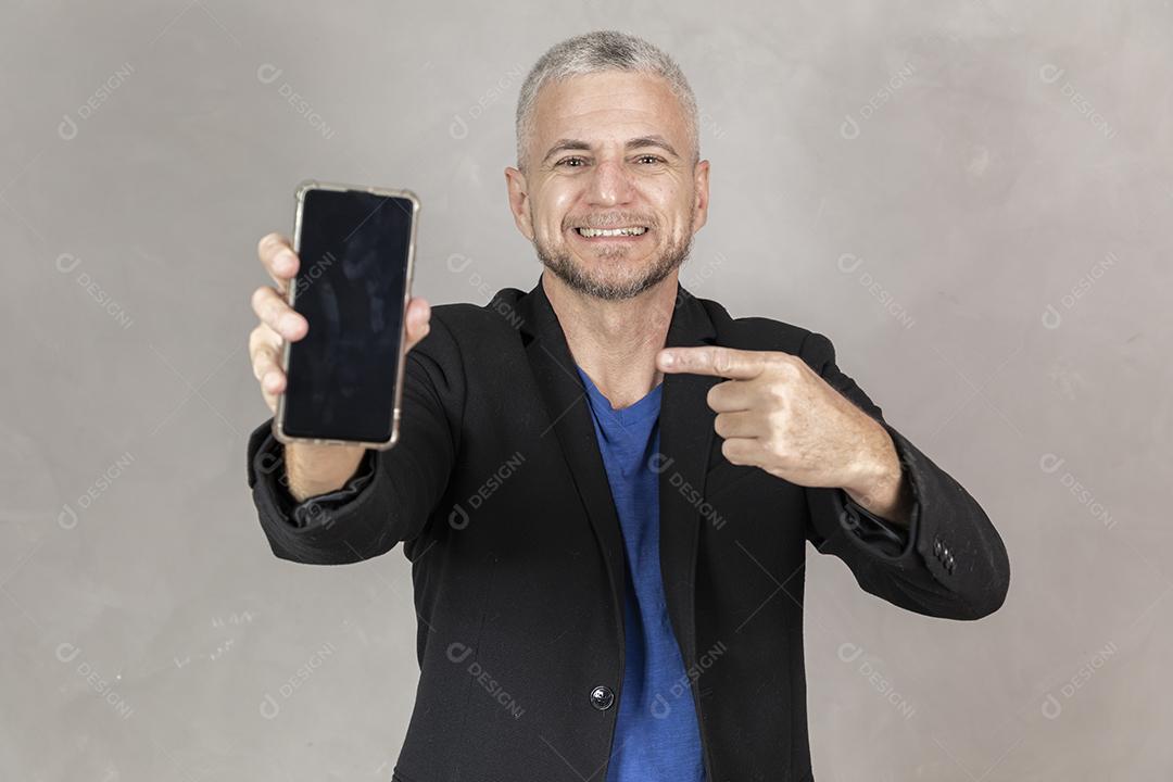 Homem maduro com um smartphone com tela em branco com espaço livre