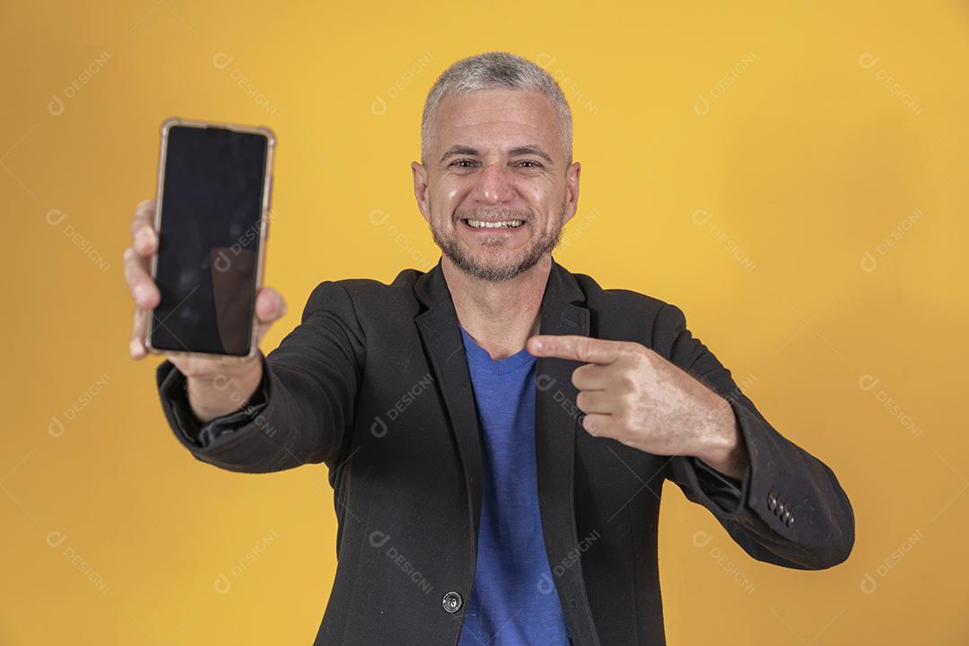 Homem maduro com um smartphone com tela em branco com espaço livre f