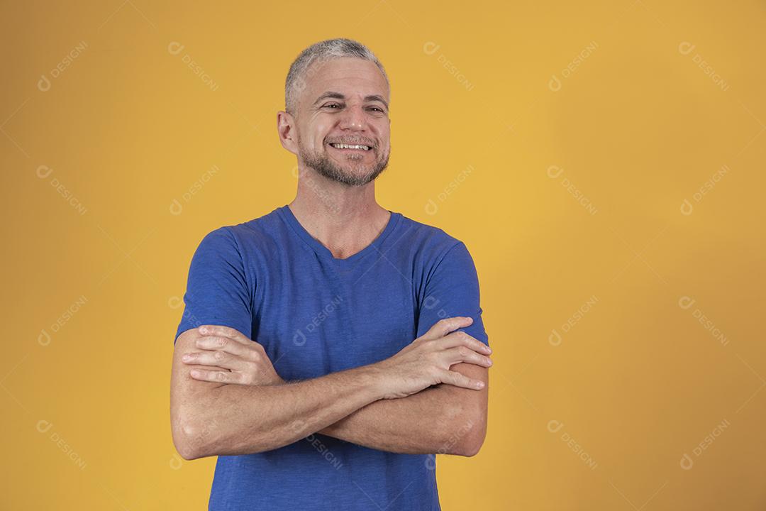 Homem maduro com os braços cruzados, olhando para a câmera