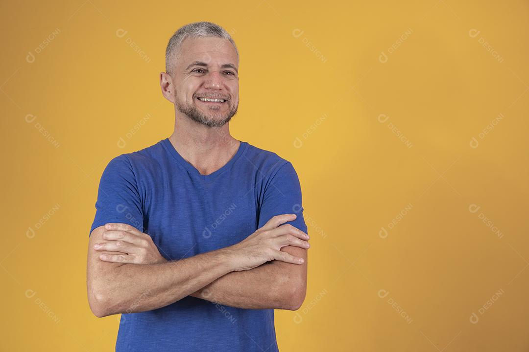 Homem maduro com os braços cruzados, olhando para a câmera