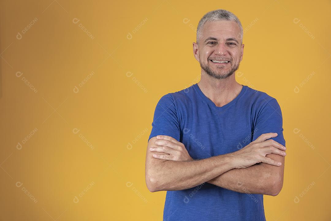 Homem maduro com os braços cruzados, olhando para a câmera