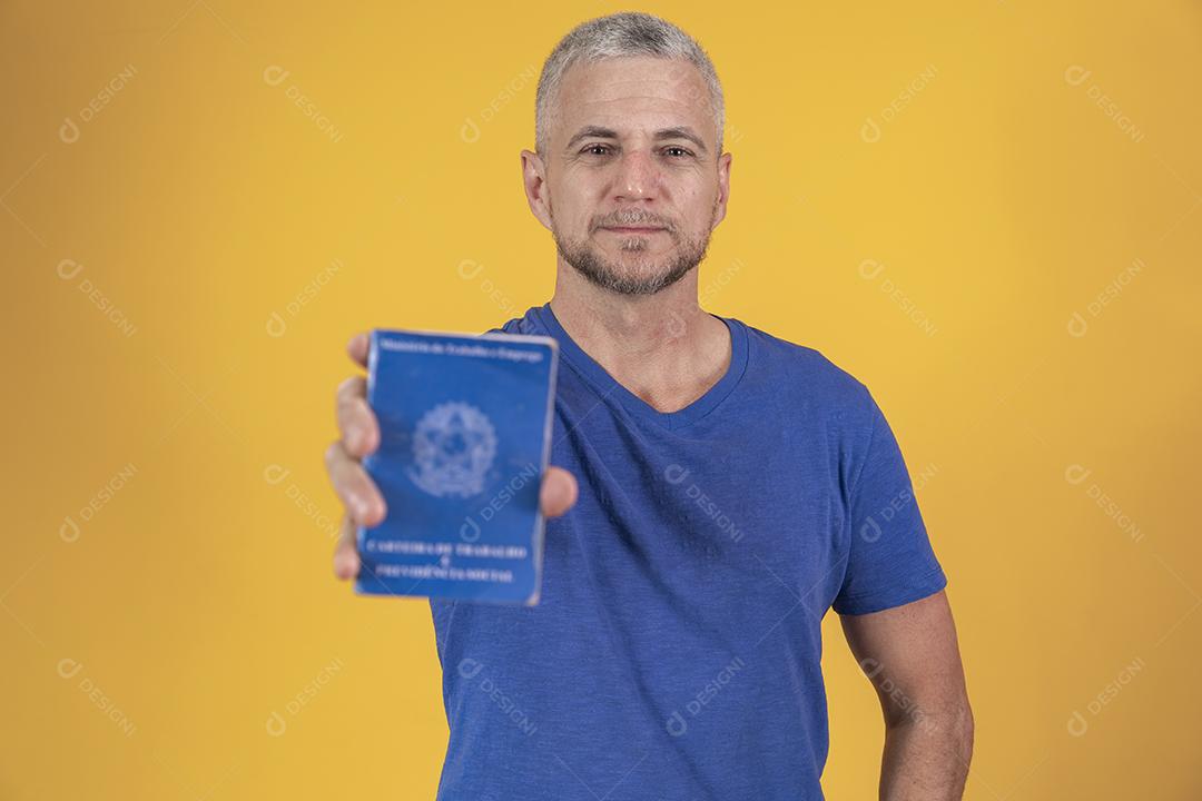 Homem de meia idade segurando carteira de trabalho