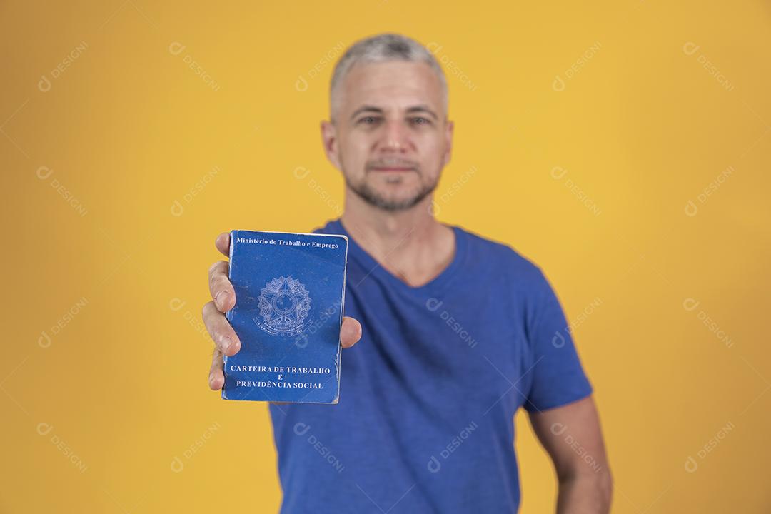 Homem de meia idade segurando carteira de trabalho