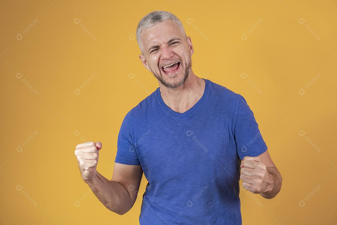 Homem brasileiro de meia idade vestindo roupas casuais comemorando